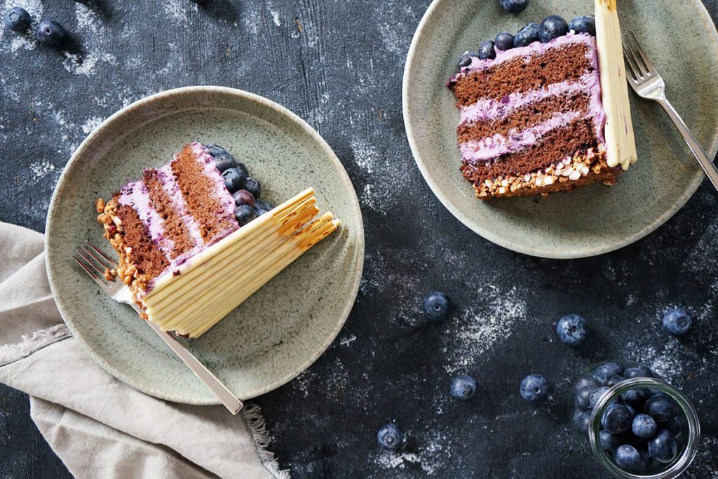 zwei Tortenstücke der Mikado-Blaubeer Torte mit Knusperboden