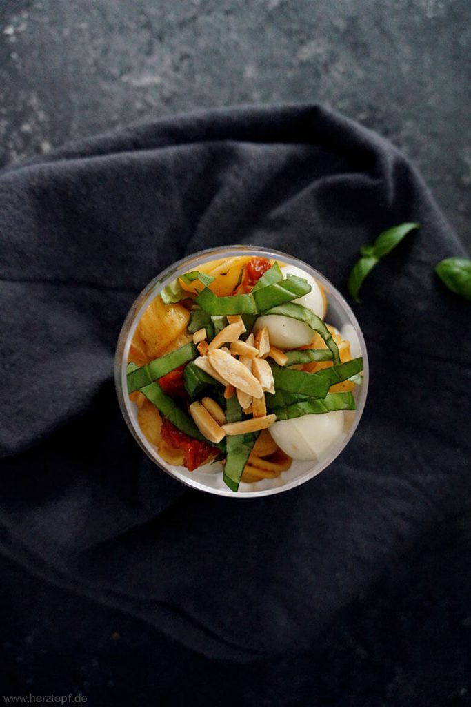 Lauwarmer Nudelsalat im Glas - mit getrockneten Tomaten, Mini Mozzarella, Basilikum und gerösteten Mandeln