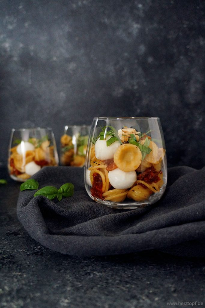 Lauwarmer Nudelsalat im Glas - mit getrockneten Tomaten, Mini Mozzarella, Basilikum und gerösteten Mandeln