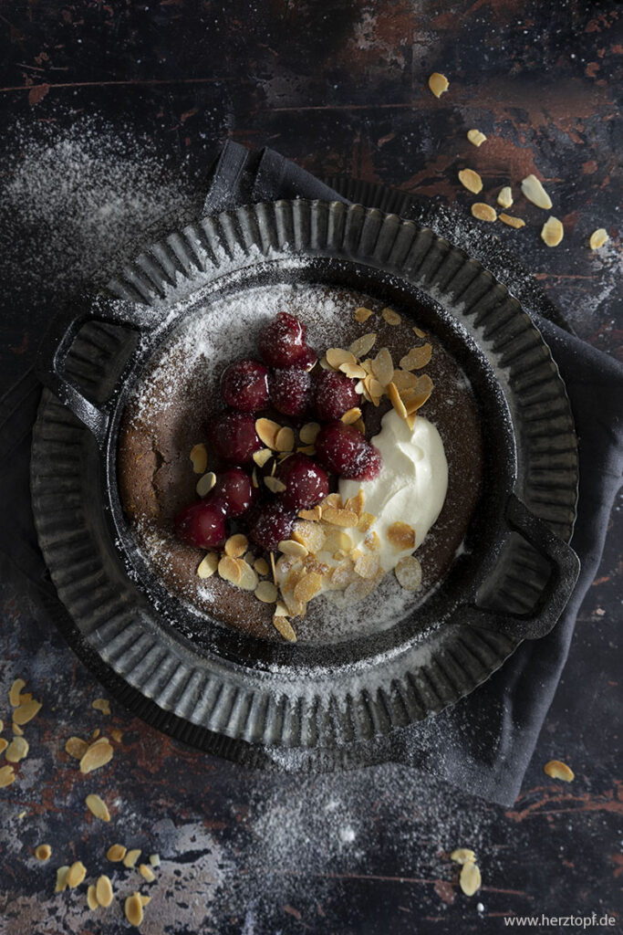 Schokoladen-Ofenpfannkuchen mit heißen Kirschen und gerösteten Mandeln